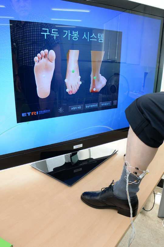 ETRI 연구자가 구두 전자가봉 분석시스템을 이용해 구두가 발에 잘 맞는지를 테스트를 하고 있다. 사진=ETRI 제공